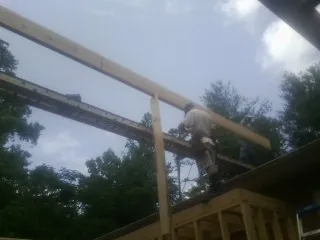 Carpenter setting a ridge beam over a new addition frame — Ice Dam Removal by Roofing Brothers in Brookville